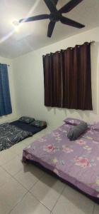 two beds in a room with a ceiling at Homestay De'69 in Jitra