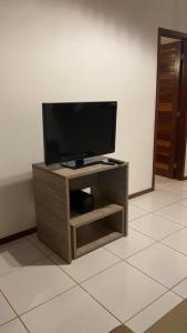 a flat screen tv sitting on top of a wooden stand at Sol da Pipa Flats Bosque da Praia in Pipa