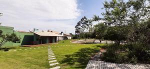 a yard with a pathway in front of a house at IbiraCottage in Imbituba