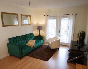 a living room with a green couch and a chair at Cozy Condo near Buckhead in Atlanta