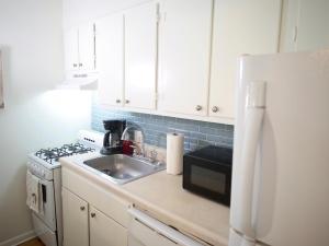a kitchen with a sink and a white refrigerator at Cozy Condo near Buckhead in Atlanta +8 photos