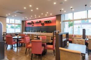 a restaurant with tables and chairs and a bar at Hotel Lifetree Hitachinoushiku in Ushiku