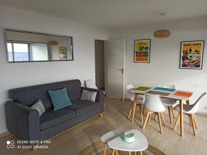 a living room with a couch and a table at Vue mer exceptionnelle in Le Lavandou