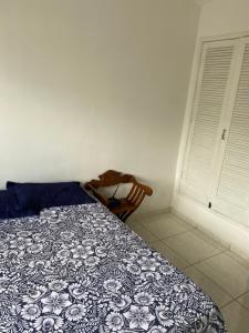 una camera con un letto e una sedia accanto a una finestra di Flat a 500 metros do centro a São Lourenço