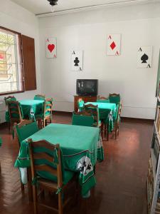 una stanza con tavoli e sedie verdi con carte da gioco appese al muro di Flat a 500 metros do centro a São Lourenço