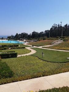 una pasarela a través de un parque junto a un cuerpo de agua en Laguna Bahía Fernanda en Algarrobo