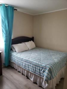 1 dormitorio con 1 cama con cortina azul en Laguna Bahía Fernanda, en Algarrobo