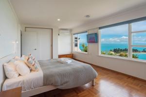 a bedroom with a bed with a view of the ocean at Ocean Vista in Nelson