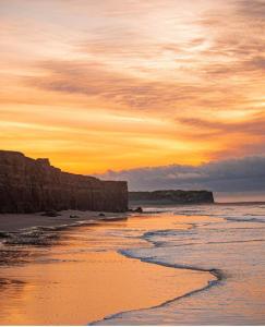 a sunset over a beach with the ocean at Evergreen in Mar del Plata