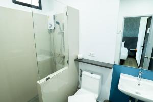 a bathroom with a toilet and a sink at Kuda Asia Hotel Bang Saen in Bangsaen