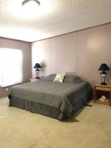 - une chambre avec un lit et deux lampes sur les tables dans l'établissement Orange Beach! Spacious mobile home near the beach!, à Orange Beach