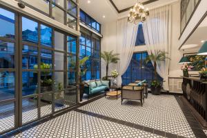 a living room with large windows and a chandelier at ARTIS Hotel Da Lat in Da Lat