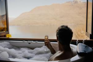 
a man is taking a picture of himself in the water at Azur Lodge in Queenstown
