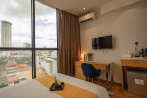 ein Hotelzimmer mit einem Bett, einem Schreibtisch und einem Fenster in der Unterkunft Summer Tree Hotel Penang in George Town