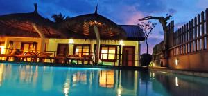 a house with a swimming pool in front of a building at Island Luxury Boutique Hotel - Fulhadhoo in Fulhadhoo
