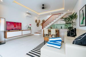 sala de estar con sofá y TV en Vienna Villas, en Seminyak