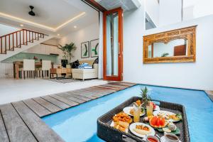 a tray of food on a pool in a living room at Vienna Villas in Seminyak