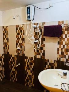 een badkamer met een wastafel en een douche bij Thathsara Holiday Inn in Sigiriya