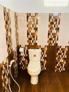 een badkamer met een toilet in een kamer met tegels bij Thathsara Holiday Inn in Sigiriya