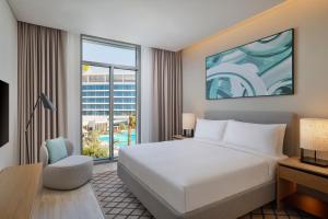 a hotel room with a large bed and a large window at Doubletree By Hilton Abu Dhabi Yas Island Residences in Abu Dhabi