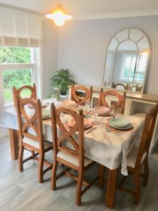 a dining room with a table with chairs and a mirror at The Old Bark House No 3 in Mevagissey