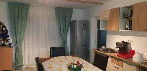 a kitchen with a table and a refrigerator at La Anda in Ruşca