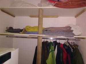 a closet with a rack of clothes and a cross at Mlle Labeaume in Aigueperse