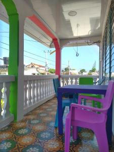 eine Veranda mit einem Tisch und Stühlen auf dem Balkon in der Unterkunft Mr. Tenloy's Place in San Andrés