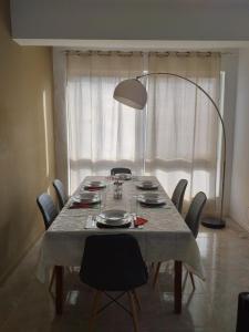 uma mesa de jantar com cadeiras e um candeeiro em Bright apartment in the town center em Praia