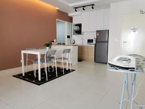 Rumah Sarah Semenyih في سيمينيه: مطبخ مع طاولة وكراسي وثلاجة