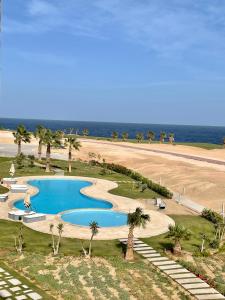 einen Blick über einen Pool neben einem Strand in der Unterkunft Soma Bay Apartment in Hurghada