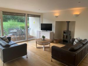 a living room with a couch and a table with a fireplace at Harrier Lodge in Cirencester