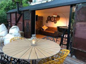 a table with an umbrella sitting on a deck at Vagón Orient Express - Housevanlive in Casas Altas