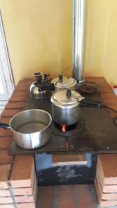two pots and pans on a stove in a room at Recanto Sananda in São José dos Pinhais