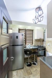 a kitchen with a stainless steel refrigerator and a counter at Sud Dreams Apartments in Bucharest