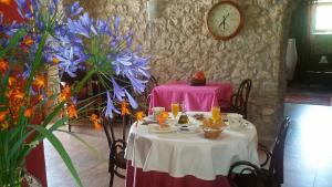 a table with a pink table cloth on it with a clock at Posada El Salin in Muñorrodero