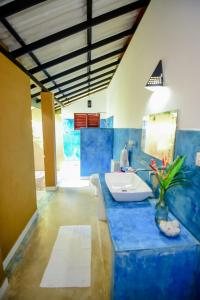 a bathroom with a blue counter with a sink at Randoni Villa in Raddoluwa