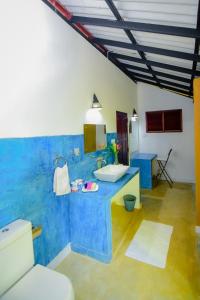 a blue and white bathroom with a sink and a toilet at Randoni Villa in Raddoluwa