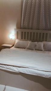 a bed with white sheets and pillows in a bedroom at Altaraf Resort in Al Shafa