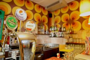 a restaurant with a bar with yellow and orange walls at Sunflower City Student Hostel & Bar in Rimini