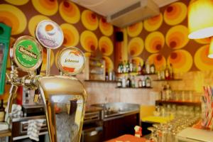 a restaurant with a bar with yellow and orange walls at Sunflower City Youth Hotel in Rimini