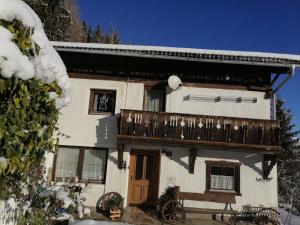 una casa con balcone e neve di Ferienwohnung Riedbach a Innsbruck