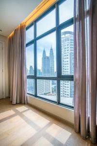 クアラルンプールにある188 Suites KLCC by CoBNBの市街の景色を望む大きな窓が備わる客室です。