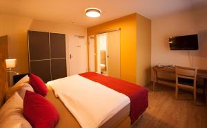 a bedroom with a bed and a desk and a television at Landgasthof Schneider, Westfeld in Schmallenberg