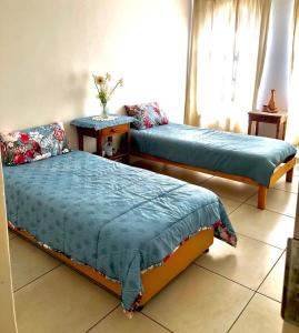 Un dormitorio con dos camas y una mesa y una ventana. en THEE VIEW, en Hartbeespoort 20 fotos más