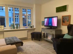 a living room with a flat screen tv and a couch at P11 Vakantiehuis in Friedrichstadt