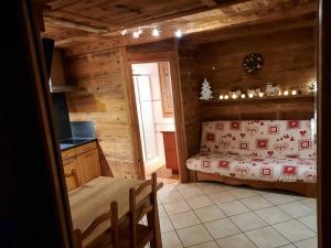 ein Schlafzimmer mit einem Bett in einer Holzhütte in der Unterkunft Le petit caboin in Seytroux