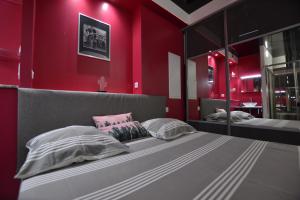 a bedroom with two beds and a red wall at Studio Naturiste "LE CACTUS" Coursives Port Nature 614 in Cap d'Agde