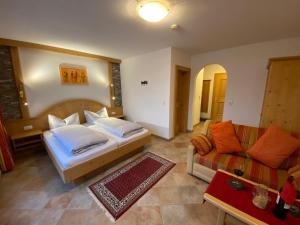 ein Schlafzimmer mit einem Bett und einem Sofa in der Unterkunft Appartement Gafluna in Sankt Anton am Arlberg