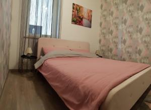 um quarto com uma cama com um cobertor rosa em Sunset Apartman em Siófok